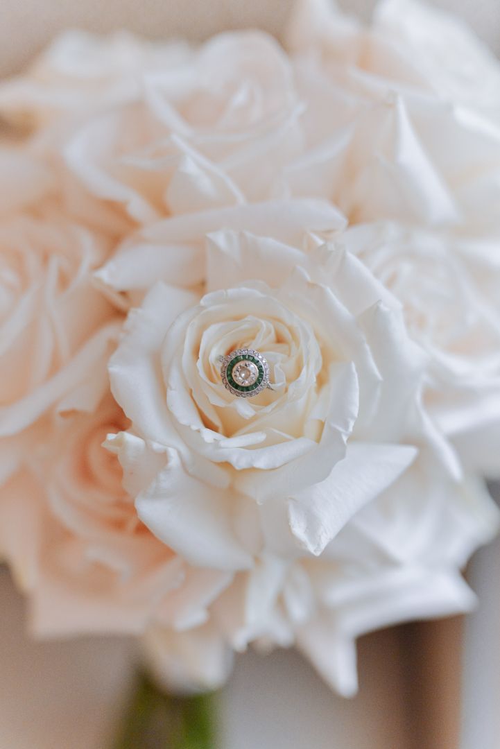 an engagement ring inside a white rose